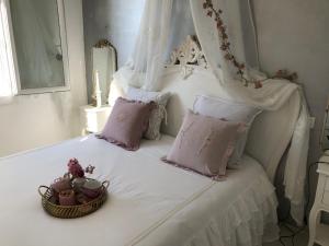 Una cama blanca con una cesta de flores. en MAISON CHATEAU D'OLERON en Le Château-dʼOléron