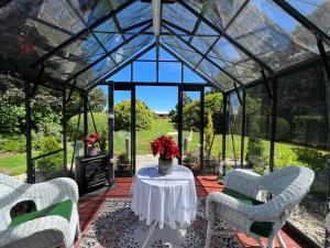 a conservatory with a table and chairs and a fireplace at Highgrove in Promised Land