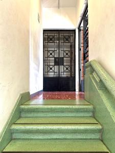 una puerta delantera de una casa con una escalera verde en Hotel Boutique Casa Degollado, en Colima