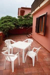 a white table and two chairs on a patio at Dimore Dell'Isola Rossa in Isola Rossa