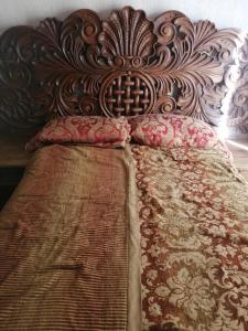 uma cama grande com cabeceira e almofadas de madeira em Acogedora casa estilo mexicano em Dolores Hidalgo