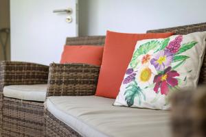 a brown wicker couch with a colorful pillow on it at Casa do Arco in Ponta Delgada +20 photos