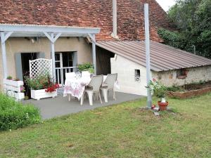 een patio met een tafel en stoelen voor een huis bij Gîte Val-Fouzon, 3 pièces, 5 personnes - FR-1-591-345 in Val-Fouzon