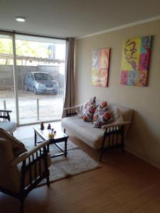 sala de estar con sofá y ventana grande en Departamento Full Equipado y Central, en Talca