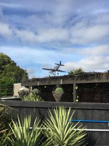 een vliegtuig vliegt laag boven een huis bij Aarburg Airport Motel in Christchurch