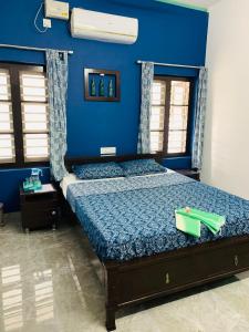Schlafzimmer mit einem Bett mit blauer Wand in der Unterkunft Peacock Villa Marari Beach in Mararikulam