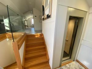 una escalera en una casa con suelo de madera y pared de cristal en Ático tipo loft en San Sadurniño., en Santa María La Mayor del Rosario