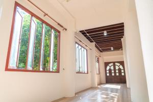 un couloir vide avec une grande fenêtre dans un bâtiment dans l'établissement Sakk - Lanna Heritage Stay, à Ban Mae Hom