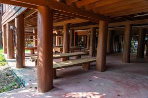 un groupe de bancs en bois assis sous un pavillon dans l'établissement Sakk - Lanna Heritage Stay, à Ban Mae Hom