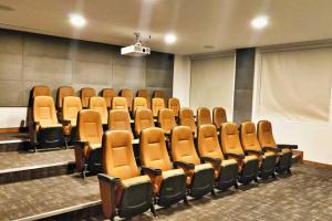 an auditorium with brown chairs in a room with a screen at Beautiful Hi-rise, King size, HS Wi-Fi, pool, gym in Mexico City +20 photos