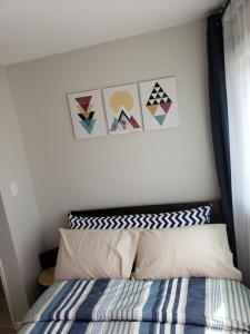 a bedroom with a bed and some pictures on the wall at Choose, 1of 2 entire! appart- 1BR-1sofa bed king size-free prkg- at Mohawk college city of falls in Hamilton