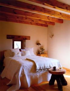 Un dormitorio con una gran cama blanca y una mesa en Las Casas del Palomar I & II, en Ortigosa del Monte