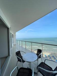 balcón con mesa, sillas y vistas al océano en Apartamento con vista al mar, en Cartagena de Indias