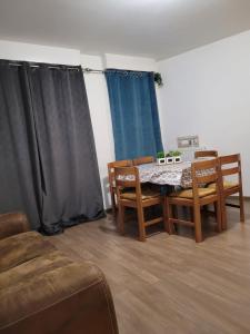 ein Esszimmer mit einem Tisch, Stühlen und Vorhängen in der Unterkunft Boissy Gare RER A Appartement 1 à 3 chambres au choix in Boissy-Saint-Léger