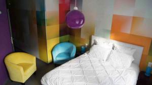 - une chambre avec un lit et deux chaises dans l'établissement Les Béthunoises Centre Grand-Place - Spa et Sauna, à Béthune