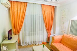 un soggiorno con divano arancione e finestra di Villa Tamara a Bucarest