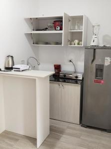 a kitchen with a white counter and a refrigerator at Edificio Sánchez Cerro in Piura