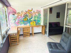 a room with a table and a wall covered in graffiti at Rock Hostel Medellin in Medellín