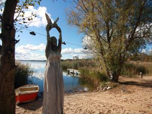 a statue of a woman with her hands in the air at Beachy Caravan am Achterwasser, Lütow in Lütow +3 photos