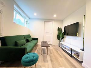 a living room with a green couch and a flat screen tv at Perfect Workation Spot, Fast Wi-Fi, Fully Stocked in Seattle