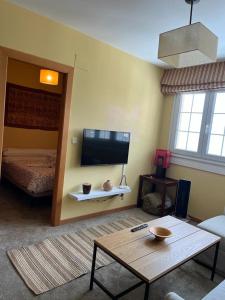 een woonkamer met een tv en een tafel en een bed bij MARIBEL ELITE junto pistas in Sierra Nevada