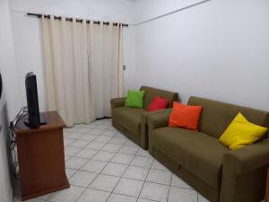 sala de estar con 2 sofás y almohadas coloridas en Linda vista para a praia em Mongaguá, en Mongaguá