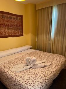 een slaapkamer met een bed met twee handdoeken erop bij MARIBEL ELITE junto pistas in Sierra Nevada