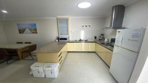 a kitchen with a white refrigerator and a table at Unit 48 Seafront Estate in Jurien Bay