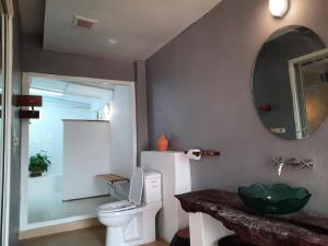 a bathroom with a white toilet and a mirror at Pingplalee Resort in Sai Yok