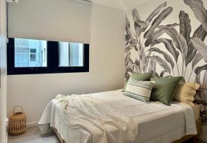 1 dormitorio con 1 cama con un mural de plantas en la pared en Hermoso departamento en Palermo Soho en Buenos Aires