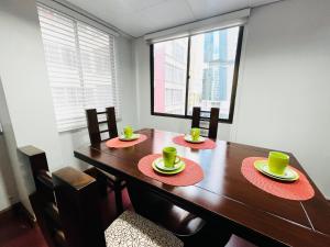 a dining room table with two green cups on top of it at Elegante y Funcional Apartamento en zona comercial de Sopocachi in La Paz
