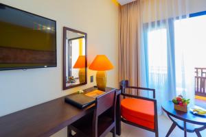 a hotel room with a desk and a table with a lamp at Pandanus Resort in Mui Ne