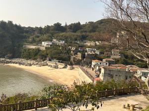 a view of a beach with houses on a hill at 雲台客棧民宿 in Nangan