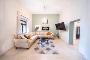 a living room with a couch and a table at Art Apartment In Mamila - Villa Rehavia in Jerusalem