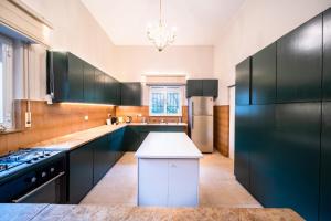 a kitchen with black cabinets and a white counter top at Art Apartment In Mamila - Villa Rehavia in Jerusalem