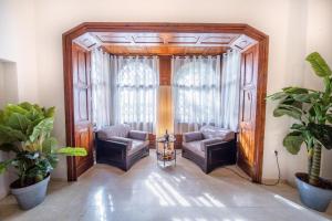 a living room with two chairs and a large window at Art Apartment In Mamila - Villa Rehavia in Jerusalem