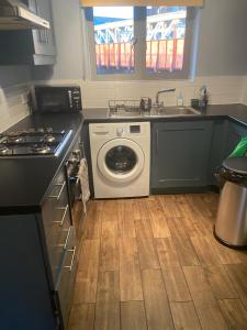 una cucina con lavatrice e lavandino di Spacious 1-bed flat in North Kensington a Londra