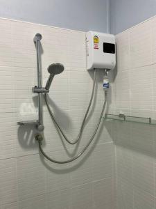 a shower in a bathroom with a hose attached to a wall at Na - cha - lae (3) in Chanthaburi