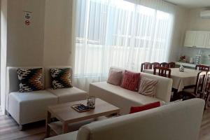 a living room with two couches and a table and a dining room at Na - cha - lae (3) in Chanthaburi