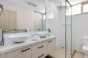 a bathroom with two sinks and a glass shower at Yera Lodge Coastal Homestead in Rye Spa/Tennis Crt in Rye