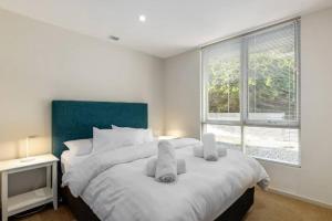 ein Schlafzimmer mit einem großen Bett mit Handtüchern darauf in der Unterkunft Yera Lodge Coastal Homestead in Rye Spa/Tennis Crt in Rye