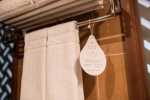 a towel rack with two towels and a tag on it at Pandanus Resort in Mui Ne