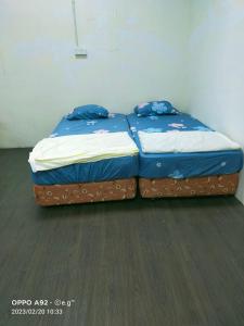 2 camas individuales sentadas una al lado de la otra en una habitación en KERAYONG IMPIAN HOMESTAY, en Kampong Kerayong
