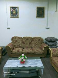 sala de estar con sofá y mesa con flores en KERAYONG IMPIAN HOMESTAY, en Kampong Kerayong