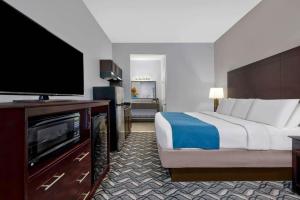 a hotel room with a bed and a flat screen tv at Studio 6-Pleasanton, TX in Pleasanton