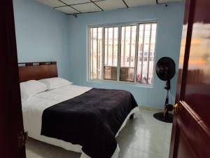 Schlafzimmer mit einem Bett und einem Fenster in der Unterkunft Casa Hotel Quimbaya in Quimbaya