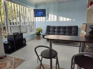 ein Wohnzimmer mit einem Tisch und einem Sofa in der Unterkunft Casa Hotel Quimbaya in Quimbaya