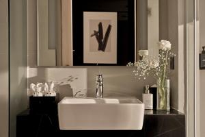 ein Badezimmer mit einem weißen Waschbecken und einem Spiegel in der Unterkunft December Hotel in Nha Trang