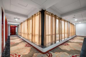 a corridor with curtains in a room with a rug at Guangzhou Shi Liu Hotel in Guangzhou