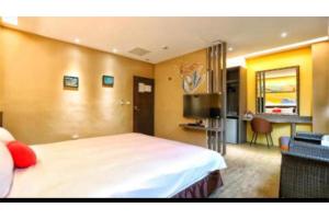 a hotel room with a large bed and a desk at 墾丁巴里巴里 in Kenting